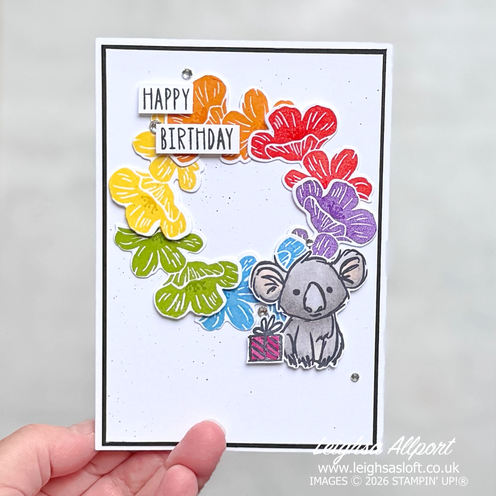 Stamp Impressions Blog Hop Challenge June 26 Sketch/Layout. Rainbow Flower Wreath using the Flowering Meadow Bundle large flowers, Poppy Parade, Pumpkin Pie, Daffodil Delight, Granny Apple Green, Azure Afternoon, Gorgeous Grape. Cute Smoky Slate Kola from the Product Of The Month Wild Bunch stamp set and Basic Black Splatter to a Basic White background, layered on to Basic Black and a Basic White cardbase. Happy Birthday sentiment and rhinestones.
