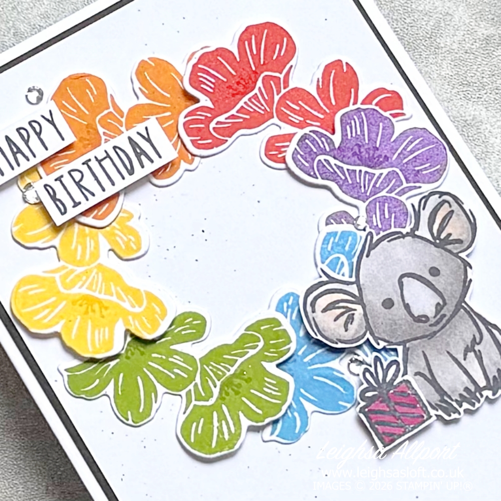 Stamp Impressions Blog Hop Challenge June 26 Sketch/Layout. Rainbow Flower Wreath using the Flowering Meadow Bundle large flowers, Poppy Parade, Pumpkin Pie, Daffodil Delight, Granny Apple Green, Azure Afternoon, Gorgeous Grape. Cute Smoky Slate Kola from the Product Of The Month Wild Bunch stamp set and Basic Black Splatter to a Basic White background, layered on to Basic Black and a Basic White cardbase. Happy Birthday sentiment and rhinestones.
