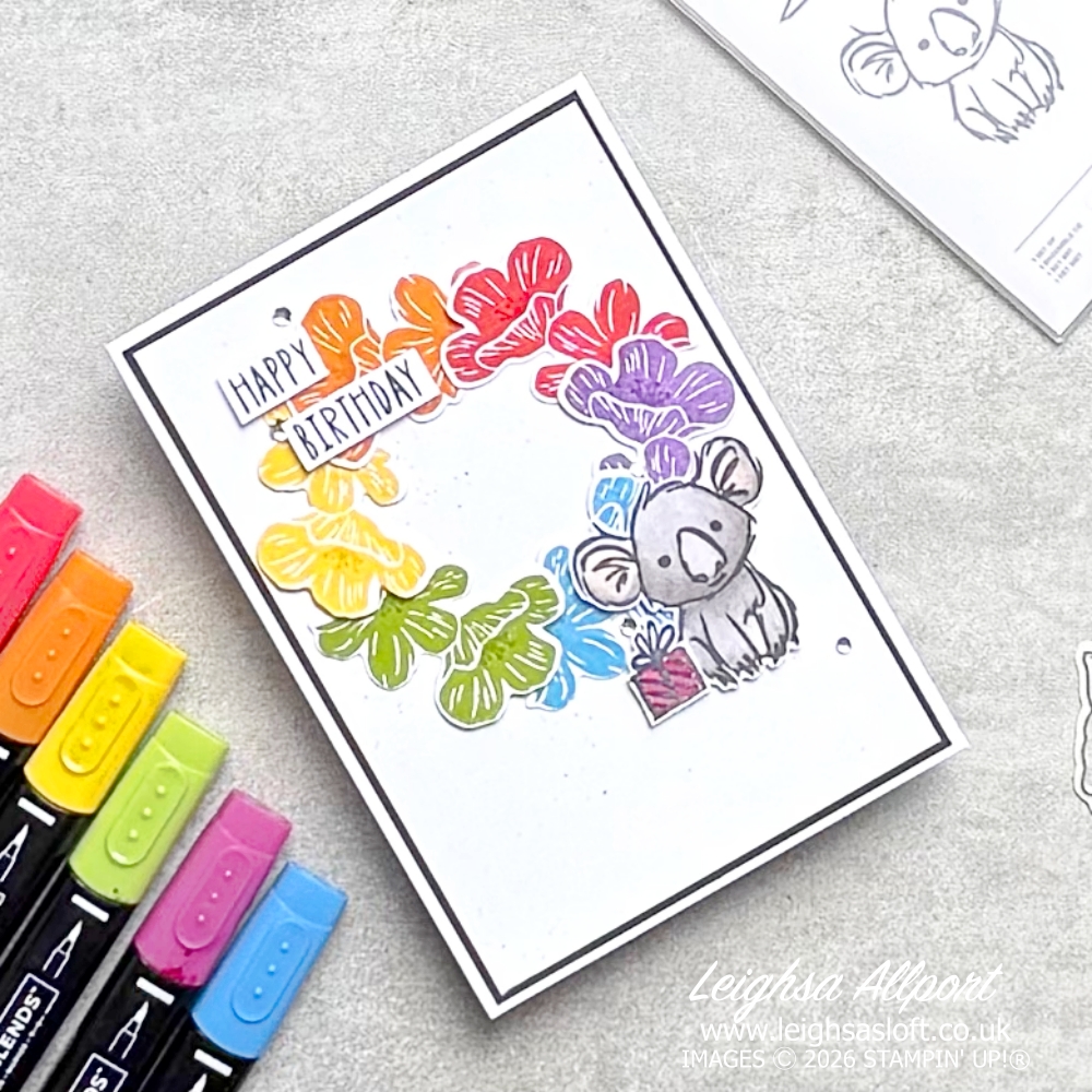 Stamp Impressions Blog Hop Challenge June 26 Sketch/Layout. Rainbow Flower Wreath using the Flowering Meadow Bundle large flowers, Poppy Parade, Pumpkin Pie, Daffodil Delight, Granny Apple Green, Azure Afternoon, Gorgeous Grape. Cute Smoky Slate Kola from the Product Of The Month Wild Bunch stamp set and Basic Black Splatter to a Basic White background, layered on to Basic Black and a Basic White cardbase. Happy Birthday sentiment and rhinestones.